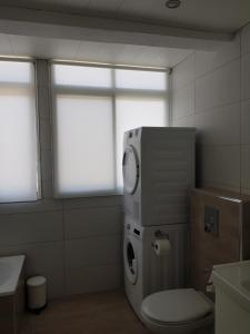 a bathroom with a toilet and a sink and a window at Exclusive Apartment - Playa de Marenys de Rafalcaid in Gandía