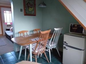 uma cozinha com uma mesa de madeira e 4 cadeiras em Bank End em Egremont