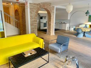 a living room with a yellow couch and a chair at 7 Hotel Particulier in Agen
