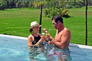 a man and a woman in a swimming pool at Sugoi House in Unawatuna