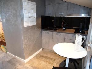 a small kitchen with a white table and a white stool at Apartments House Filipović in Makarska +104 photos