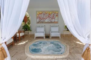 Villa Piera Maspalomas في ماسبالوماس: حوض استحمام كبير في غرفة مع كرسيين