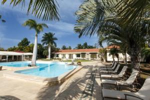 uma piscina com espreguiçadeiras e palmeiras em Villa Piera Maspalomas em Maspalomas