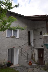 a stone house with stairs and a window at Ca da la nona in Cavigliano