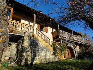 a house with a balcony on the side of it at Les Tinons in Prunières