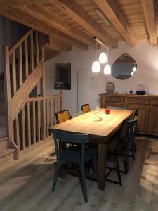 une salle à manger avec une table et des chaises en bois dans l'établissement La maison de la montagne, au Bourg-dʼOisans
