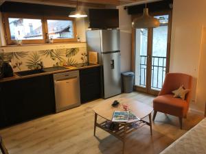 un salon avec une table et une cuisine dans l'établissement La maison de la montagne, au Bourg-dʼOisans 10 autres photos