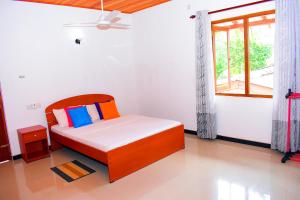 een slaapkamer met een bed en een raam bij Megabe Villa in Galle