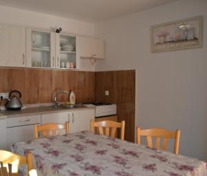 uma cozinha com mesa e cadeiras e uma cozinha com lavatório em Dom pri potoku em Zuberec