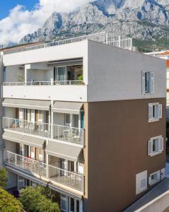 an apartment building with a mountain in the background at Apartments House Filipović in Makarska