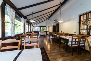 a restaurant with tables and chairs and windows at Guesthouse Bistra in Vrhnika