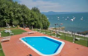 a swimming pool on a patio next to a body of water at Gardazzurro in Padenghe sul Garda