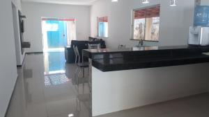 a kitchen with a black counter and a sink at PRADO-CARIBE DO NORDESTE: CASA TEMPORADA!!! in Prado