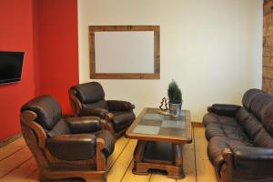 a living room with leather chairs and a table at Apartament Dobry klimat in Miedzygorze