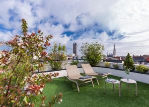 un patio avec deux chaises et une table sur le toit dans l'établissement Oceania l'Hôtel de France Nantes, à Nantes