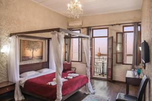 a bedroom with a large bed and a large window at Porto Antico in Chania