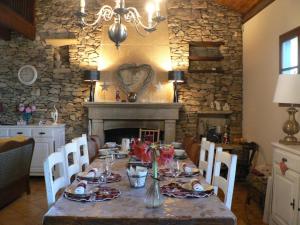 a dining room with a table and a fireplace at Le Galaveyson in Le Grand Serre