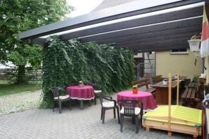 a patio with two tables and chairs under a canopy at Pension zur Krone in Eisenach