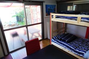 una habitación con dos literas y una ventana en HAWAIIAN COTTAGE VILLA SHIRAKO, en Shirako