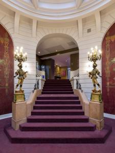 a staircase in a building with statues on the steps at Oceania l'Hôtel de France Nantes in Nantes