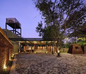 ein Gebäude mit einem Baum davor in der Unterkunft Kottawatta River Bank Resort in Udawalawe