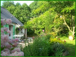 um jardim com flores e uma casa em Le Pré de la Lande em La Chapelle-sur-Erdre