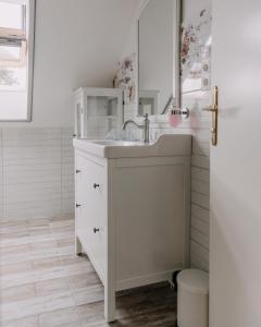 a white bathroom with a sink and a mirror at Éliás Borbirtok in Badacsonytomaj