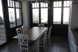 a dining room with a table and chairs and windows at Éliás Borbirtok in Badacsonytomaj
