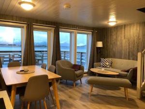 a living room with a couch and a table and chairs at Rorbu Skreda in Leknes