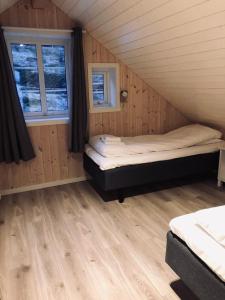 a room with two beds in a wooden cabin at Rorbu Skreda in Leknes