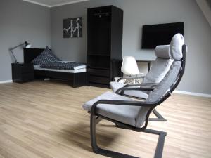 un soggiorno con sedia e letto di Moderne Monteurwohnung mit Dachterrasse für 4 Personen a Schipkau