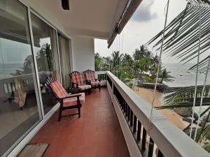 a balcony with chairs and a view of the ocean at La Veranda Di Serena in Unawatuna