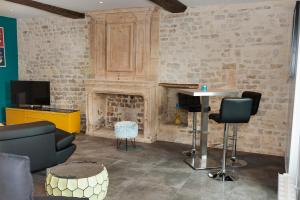 a living room with a fireplace and a table and chairs at Maison Bayeux 4 chambres in Cristot