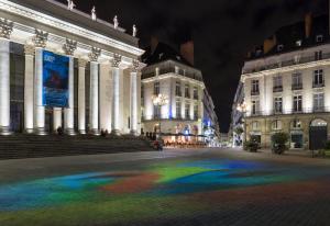 a rainbow in the middle of a street at night at Oceania l'Hôtel de France Nantes in Nantes