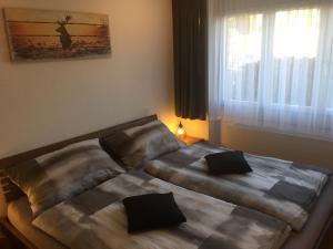 two beds in a small room with a window at Lake View Apartment in Faulensee