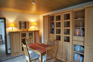 ein Esszimmer mit einem Tisch und einigen Bücherregalen in der Unterkunft Ferienwohnung Grimmelmann in Eystrup