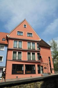 a large orange building with a person walking in front of it at Hotel Cafe Leda in Haigerloch