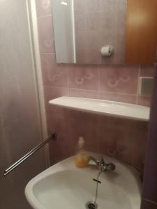 a bathroom with a sink and a mirror at Apartmani Krunić in Barbat na Rabu