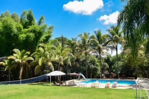 un complejo con piscina y palmeras en Rancho Hollywood - Lago de Furnas, en São José da Barra