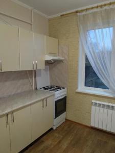 uma cozinha com fogão forno superior ao lado de uma janela em Проспект Незалежності 48 City Rooms em Bila Tserkva