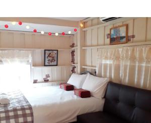 a bedroom with a white bed with two red pillows at ThaiMex Cafe & Homestay Backpackers- Adults Only in Prachuap Khiri Khan