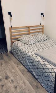 1 dormitorio con 1 cama y suelo de madera en Cosy Flat Cherbourg, en Cherbourg-en-Cotentin