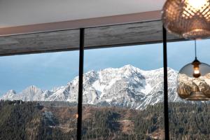 a view of a snow covered mountain from a window at Rohrmooser Schlössl in Schladming