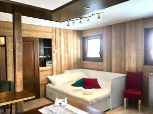 1 dormitorio con 1 cama blanca y 1 silla roja en Aroma di Legno e Profumo di Neve en Breuil-Cervinia