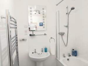 a white bathroom with a sink and a shower at Inverness City Centre Apartment with Elevator and Google Chromecast in Inverness +23 photos