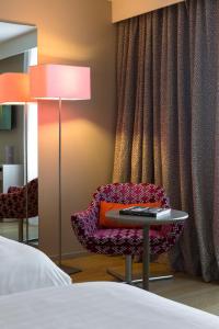 a bedroom with a table and a chair and a lamp at Oceania l'Hôtel de France Nantes in Nantes