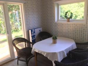 una sala da pranzo con tavolo e sedie e due finestre di Lilla Gröndal a Köpingsvik