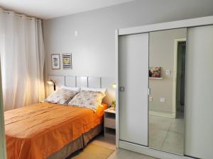 een slaapkamer met een bed en een glazen schuifdeur bij Apto 3 quartos em Araranguá in Araranguá