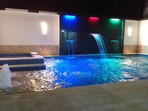 a swimming pool with a waterfall in a room at Hospedaje casa Lucía in Leticia