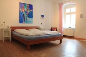 a bedroom with a bed and a painting on the wall at Pappel in Berlin